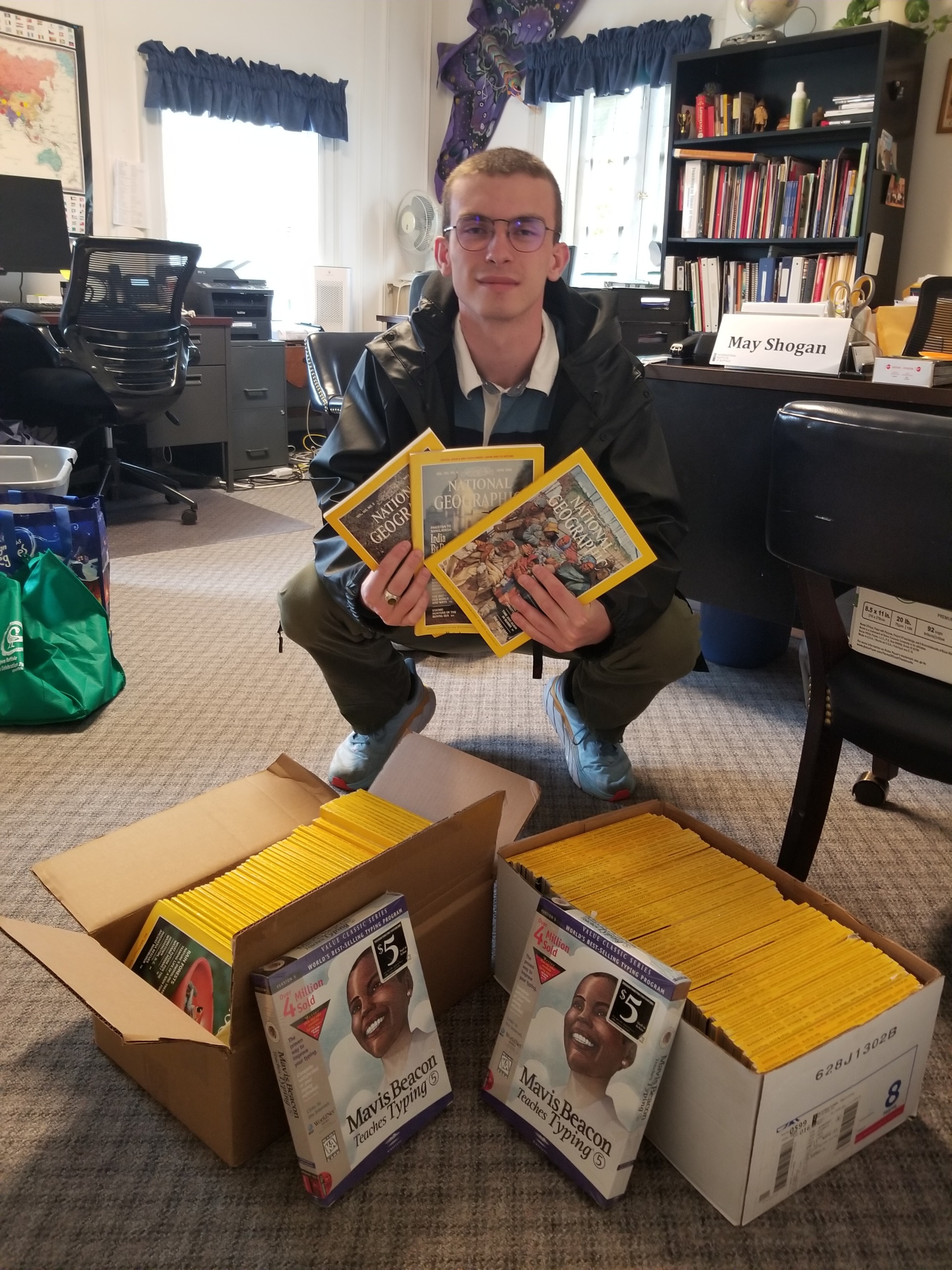 IIB International Exchanges & Education Coordinator Christopher Krull displaying parts of National Geographic Magazine collection that spans decades